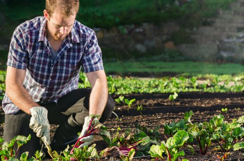 Gardener preparing a garden bed for soft landscaping work in Enfield